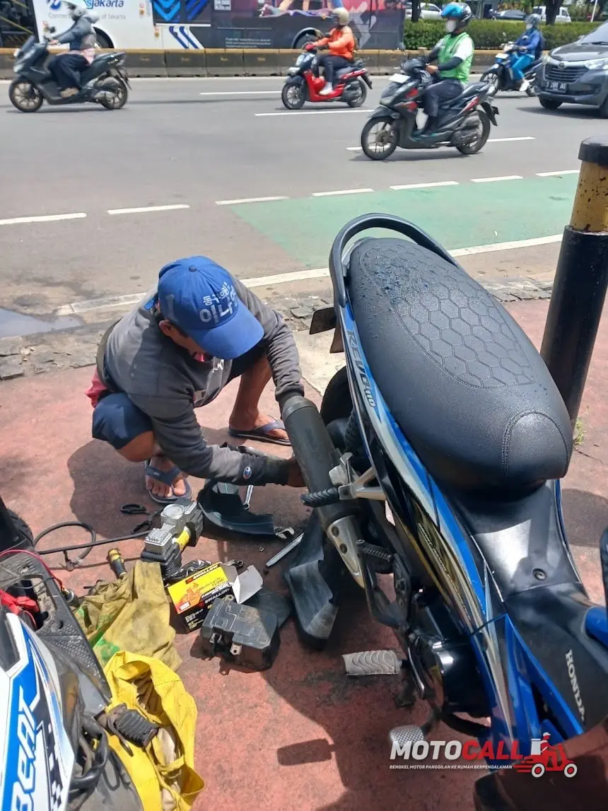 Montir MotoCall menyetel karburator motor setelah dibersihkan di lokasi pelanggan