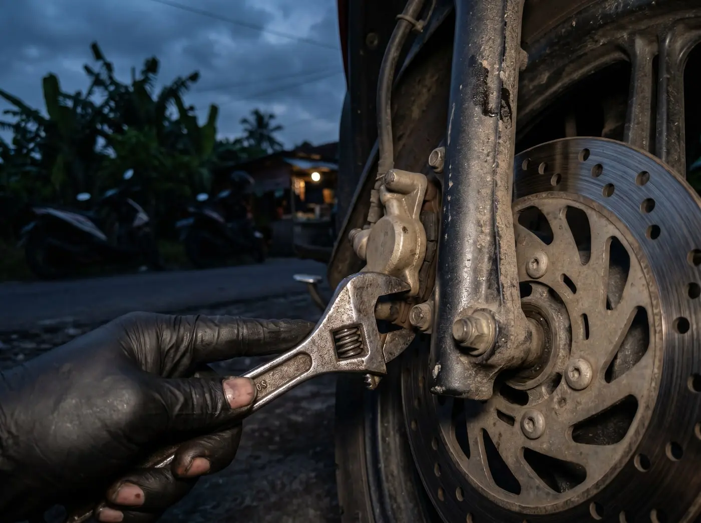 Mekanik MotoCall memeriksa rem cakram motor pelanggan untuk servis rem di lokasi